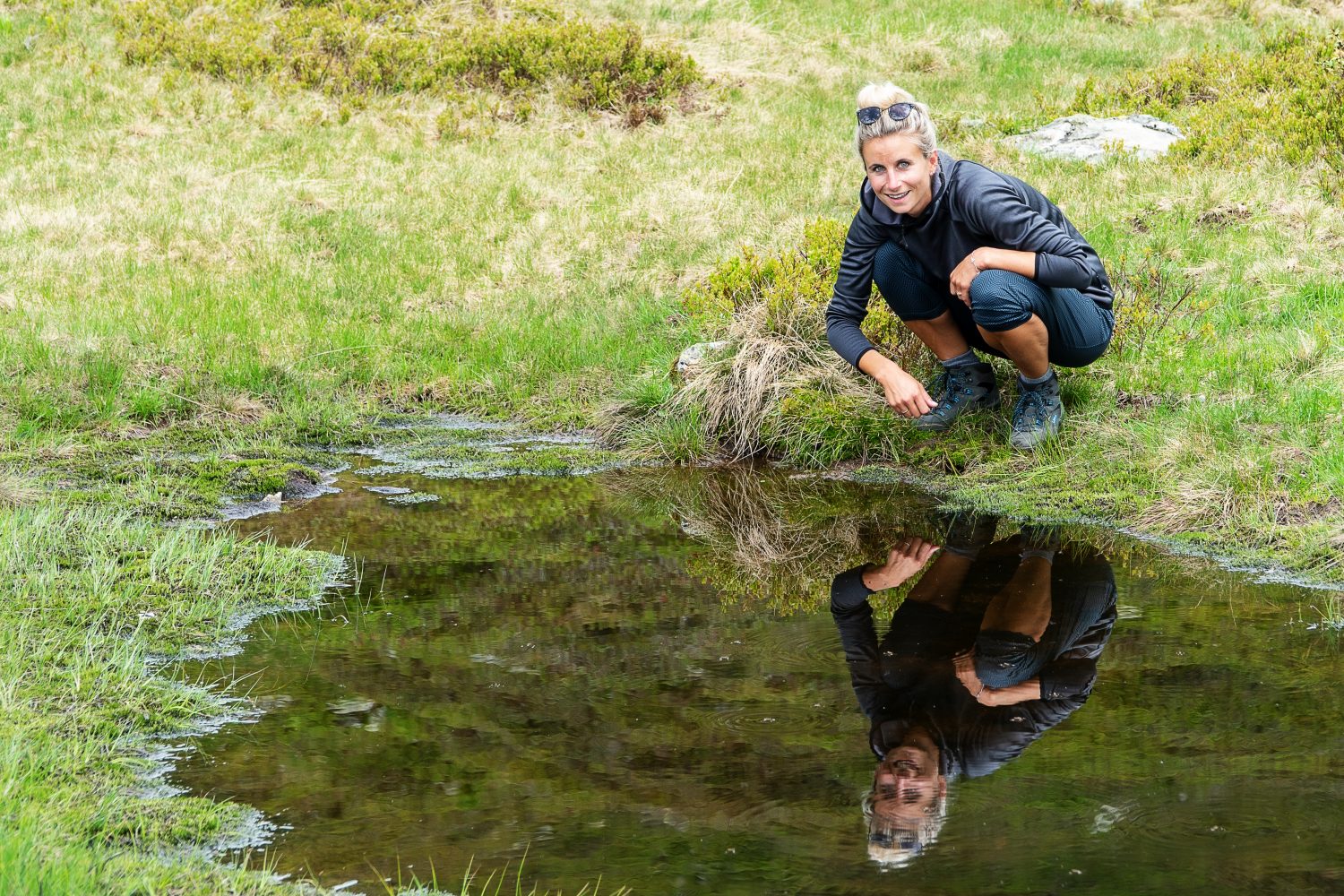 Spiegelbild einer Wanderin im Wasser am Gastein Trail