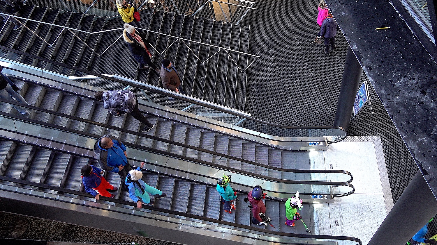 Rolltreppe mit Skifahrern