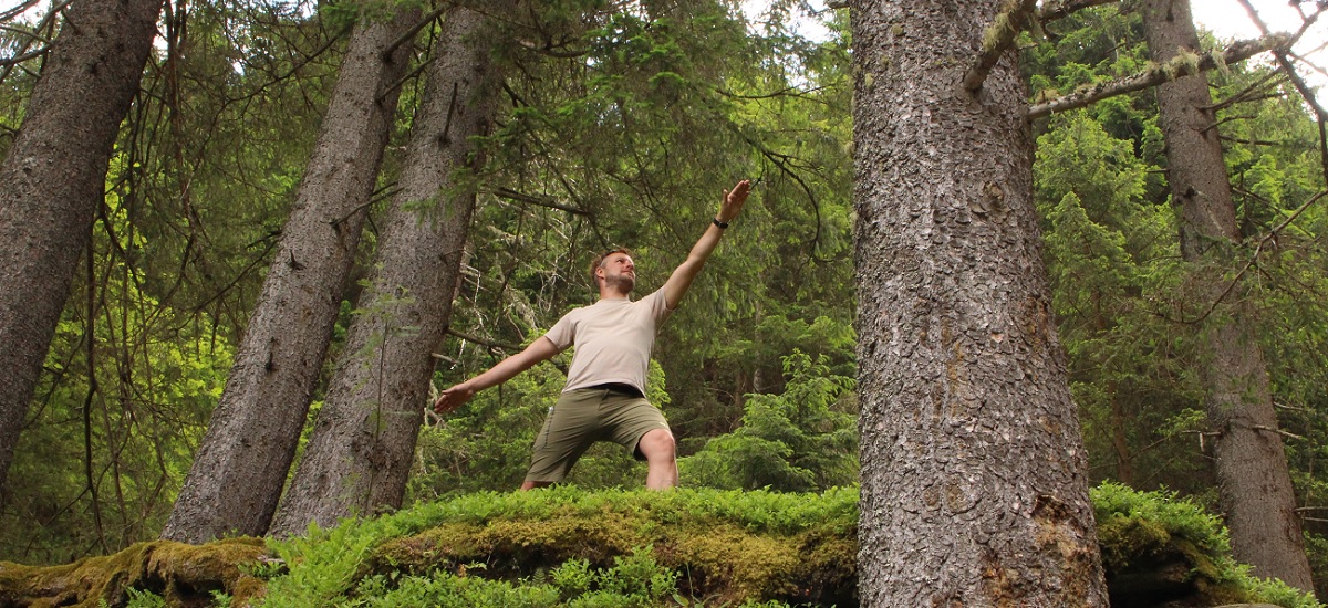 Mann im Wald in der Pose des friedvollen Kriegers