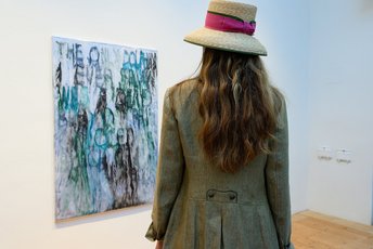 Frau betrachtet ein modernes Kunstwerk bei einer Ausstellung in Gastein