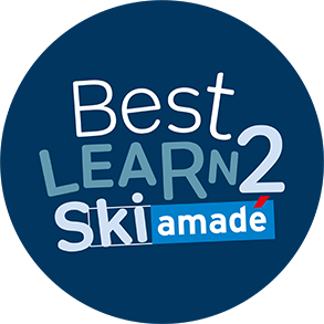 Rundes, blaues Logo mit weißem Schriftzug „Best Learn2 Ski“ und dem Zusatz „Ski amadé“ darunter.