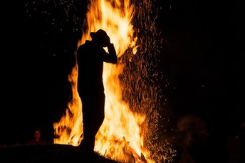 Person vorm Sonnenwendfeuer in Gastein
