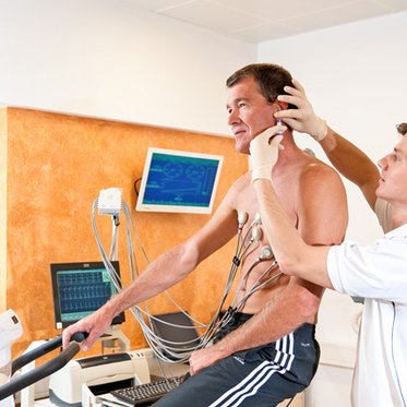 Laktatmessung des Sportmediziners bei einem Mann auf dem Ergometer