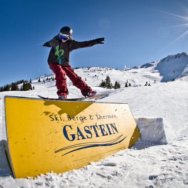 Snowboarder beim Sliden über eine Box