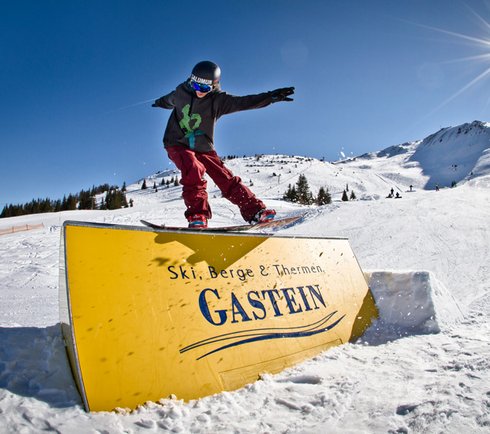  Snowboarder beim Sliden über eine Box