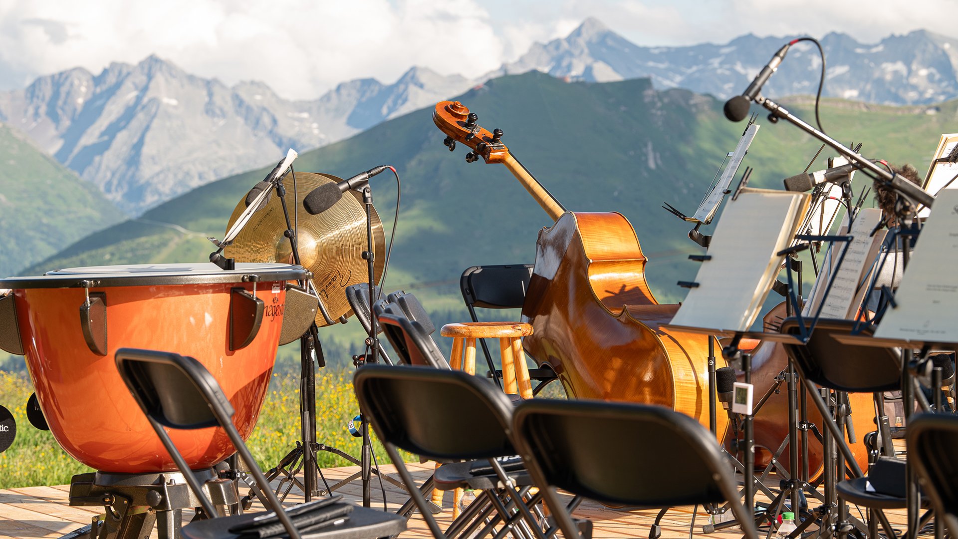 Musikinstrumente auf einer Bühne bei einem Open-Air-Konzert in alpiner Landschaft im Gasteinertal mit Bergpanorama im Hintergrund.