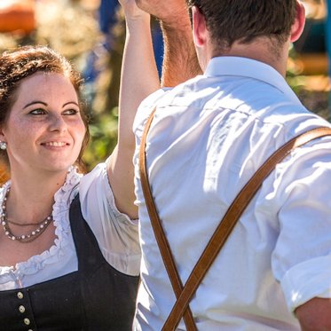 Couples in folk costume dancing to music