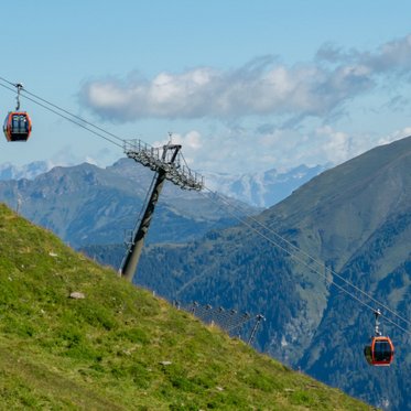 Panoramaaufnahme einer Gondelbahn mit den Gasteiner Bergen im Hintegrund
