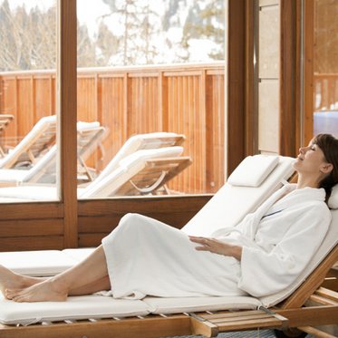 Frau im Bademantel auf der Liege im Ruheraum