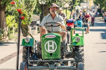Mann mit Vollbart auf altem Oldtimer Traktor