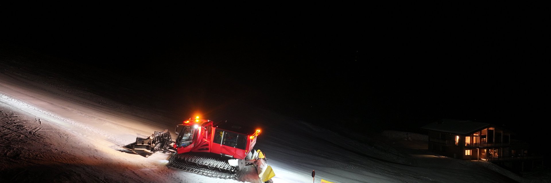 Der Pistenbully erleuchtet magisch die Piste