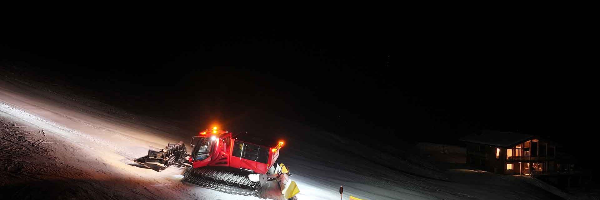 Der Pistenbully erleuchtet magisch die Piste