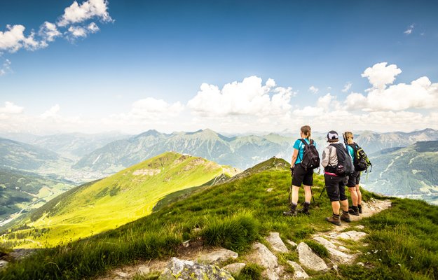 Drei Wanderer am Gipfel mit Blick über Gastein.