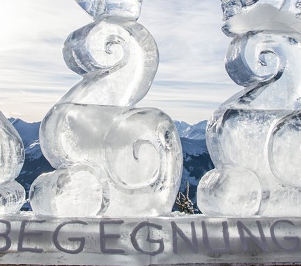 Eisskulptur am Berg mit Bergpanorama im Hintergrund