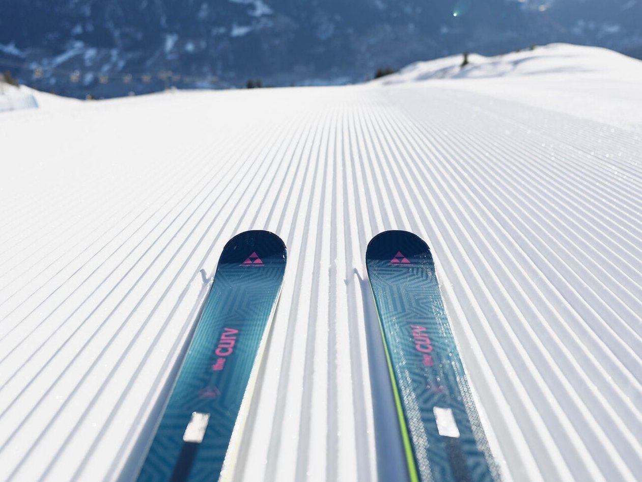 Perfekt präparierte Skipiste im Gasteinertal auf der Schlossalm mit Fischer Skiern im Vordergrund und Alpenblick