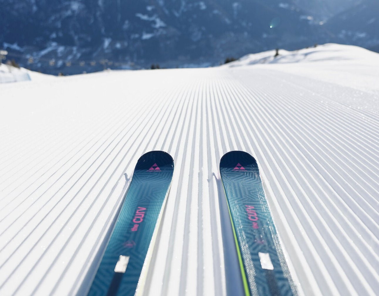 Perfekt präparierte Skipiste im Gasteinertal auf der Schlossalm mit Fischer Skiern im Vordergrund und Alpenblick