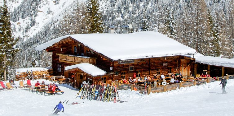 Schneebedeckte Skihütte mit Bergpanorama im Hintergrund