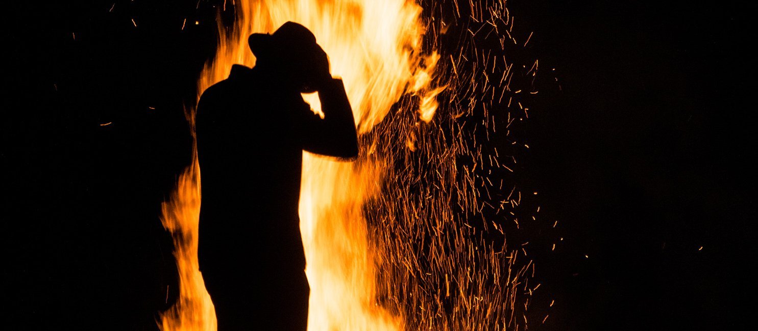 Person vorm Sonnenwendfeuer in Gastein