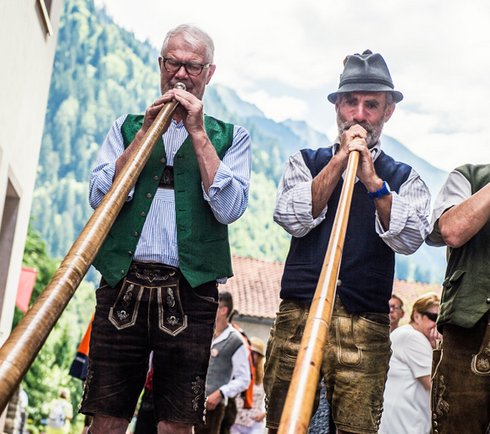 Alphornbläser in Tracht im Zentrum von Dorfgastein